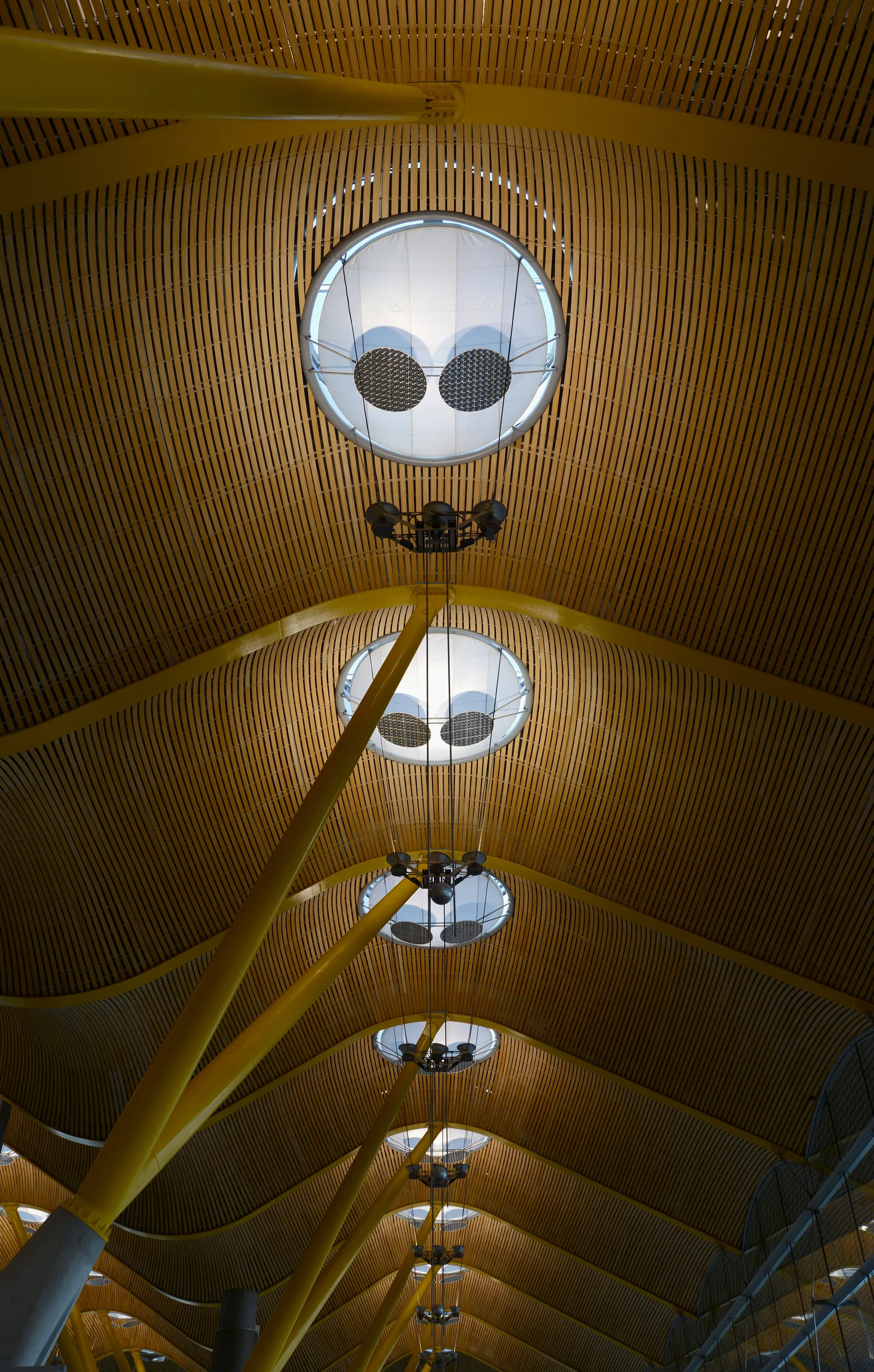 Cubierta de madera, lucernarios circulares y pilares amarillos de la terminal T4 de Madrid-Barajas