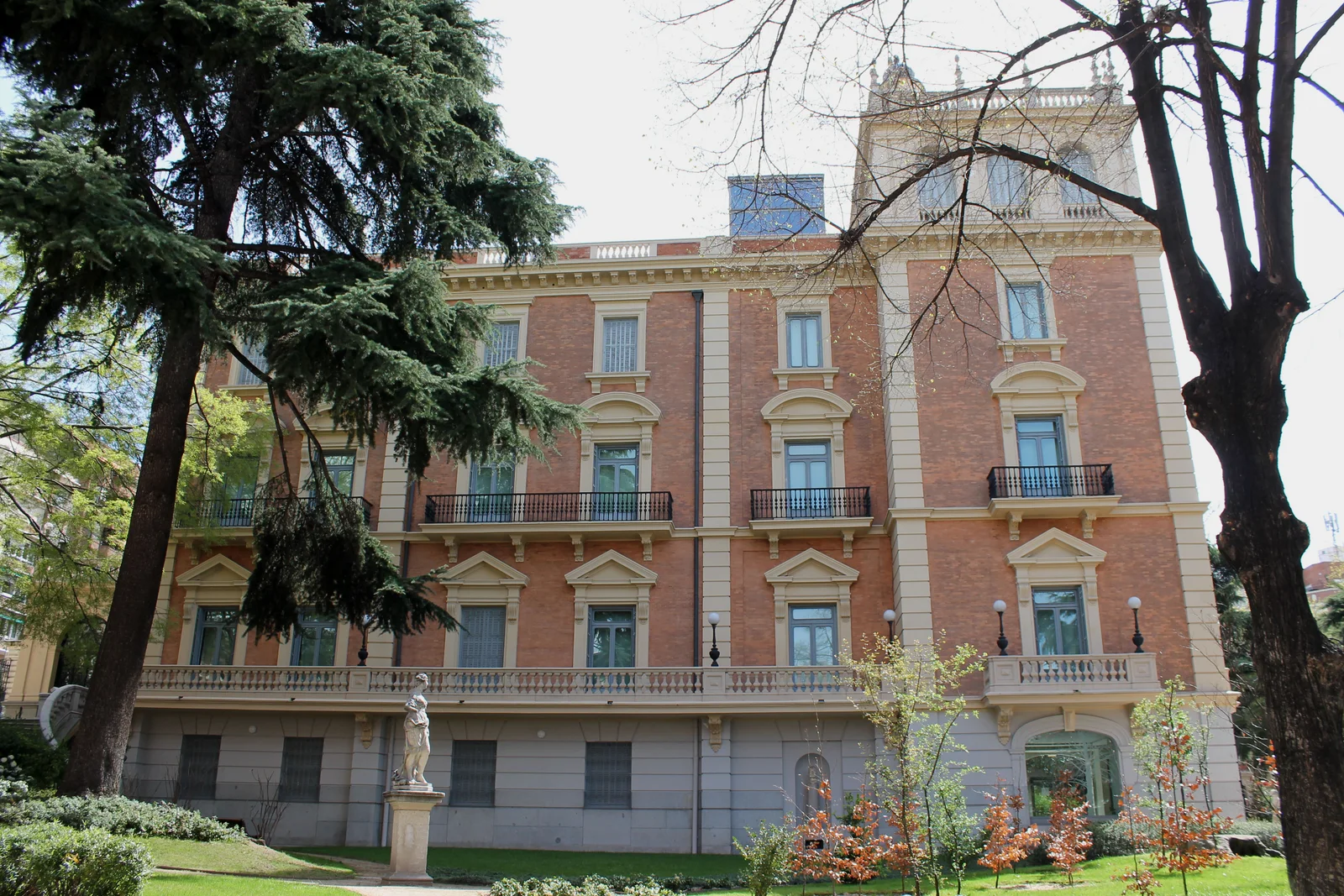 North facade of the Lázaro Galdiano Museum framed by garden trees
